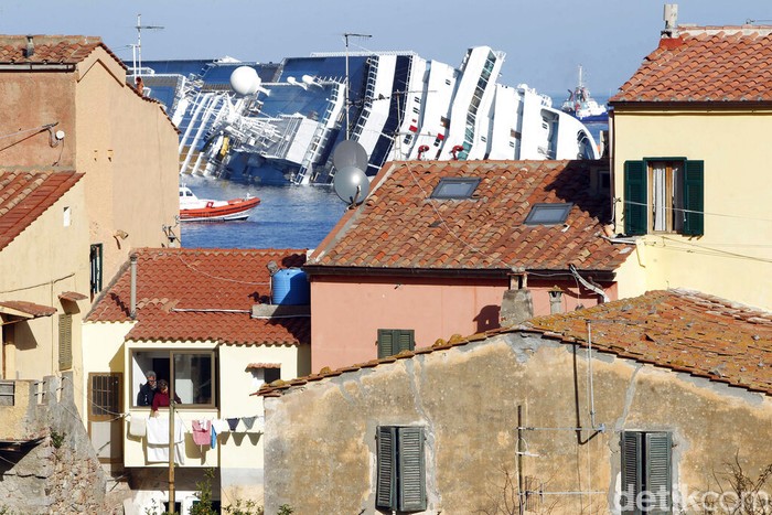 Costa Concordia FILEβ Italian firefighters conduct search operations on the luxury cruise ship Costa Concordia that ran aground the tiny Tuscan island of Isola del Giglio, Italy, Sunday, Jan. 15, 2012. Italy on Thursday, Jan. 13, 2022, is marking the 10th anniversary of the Concordia disaster with a daylong commemoration, honoring the 32 people who died but also the extraordinary response by the residents of Giglio who took in the 4,200 passengers and crew from the ship on that rainy Friday night and then lived with the Concordia carcass for another two years before it was hauled away for scrap. (AP Photo/Gregorio Borgia)