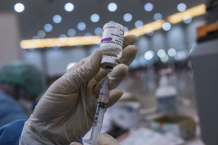 YOGYAKARTA, INDONESIA - JANUARY 13: A health worker prepares a dose of the AstraZeneca COVID-19 booster vaccine during the booster vaccination program on January 13, 2022 in Yogyakarta, Indonesia. While Southeast Asias vaccination programs have gathered pace, many countries in the region are yet to hit the high vaccination rates seen in developed nations. The emergence of Omicron in the region is adding to the urgency in countries like Indonesia, which has only fully vaccinated about 42 percent of its population as of last week, according to publicly available vaccination data. Some places in the region, such as Indonesia and Thailand, have rolled out a booster program alongside their primary vaccination programs in an attempt to aggressively bridge the gap. (Photo by Ulet Ifansasti/Getty Images)