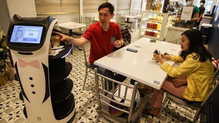 Pelayan robot melayani pelanggan di Rasa Koffie, Pasar Baru, Jakarta, Kamis (13/1/2022). Penggunaan robot di kedai kopi tersebut bertujuan untuk mengurangi kontak fisik antara pelayan dan pembeli di masa pandemi COVID-19. ANTARA FOTO/Rivan Awal Lingga/rwa.