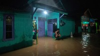 Sebagian warga memilih bertahan di rumahnya yang terendam banjir.