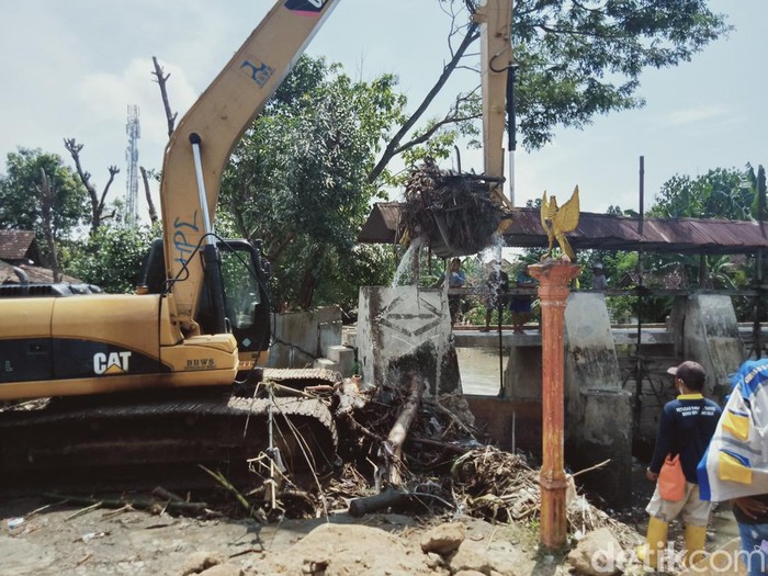 Alat berat membersihkan sampah di bendung Soka, Karangdowo, Klaten, Jumat (14/1/2022).