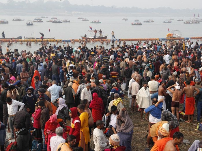 Hindu devotees crowd the Sangam, the confluence of three rivers — the Ganges, the Yamuna and the mythical Saraswati, to take a ritualistic bath during Makar Sankranti festival that falls during the annual traditional fair of Magh Mela festival, one of the most sacred pilgrimages in Hinduism, in Prayagraj, India. Friday, Jan. 14, 2022. Tens of thousands of devout Hindus, led by heads of monasteries and ash-smeared ascetics, took a holy dip into the frigid waters on Friday despite rising COVID-19 infections in the country. (AP Photo/Rajesh Kumar Singh)