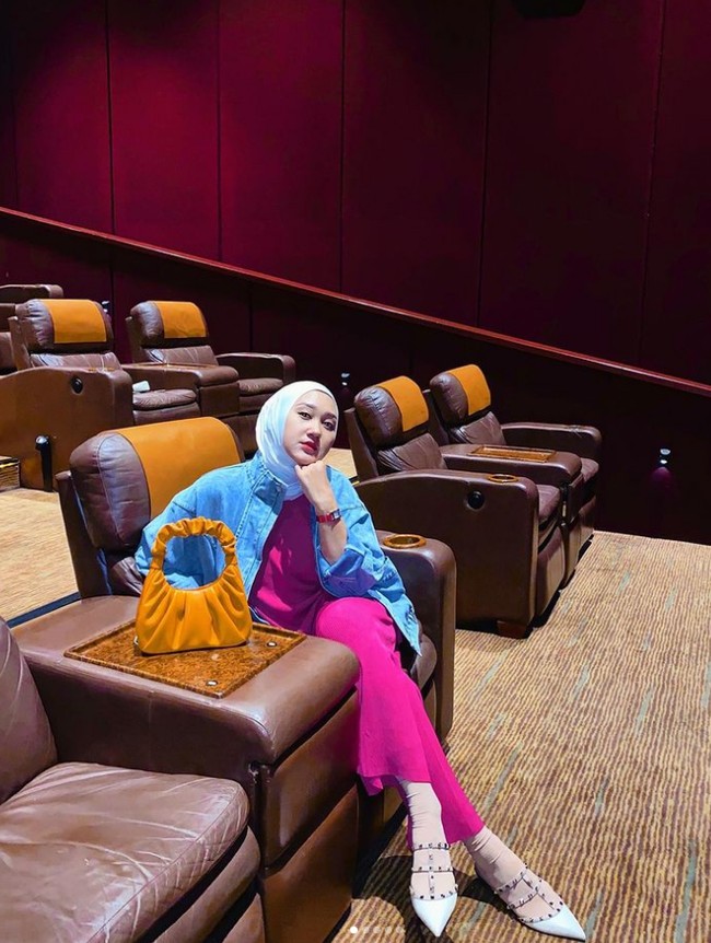 Dian Pelangi pun memilih warna neon yang pernah populer pada era 80-an. Seperti dalam foto ini ia memadukan jumpsuit warna fuchsia dan jaket denim. Agar tak semua bold, Dian memakai hijab pashmina putih dan flatshoes putih, dilengkapi dengan tas warna cokelat. Foto: Dok. Instagram @dianpelangi.