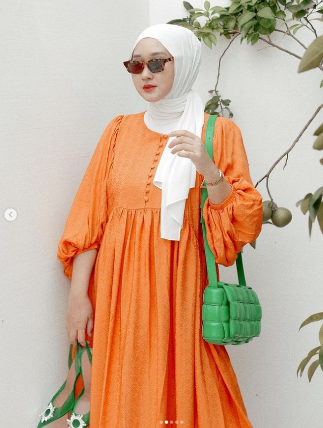 Hijab warna putih bisa kamu pilih jika ingin mengenakan outfit warna neon. Contohnya gaya Dian Pelangi satu ini. Ibu satu anak itu memakai dress warna orange neon dan hijab putih. Foto: Dok. Instagram @dianpelangi.