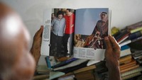 Warga menunjukan buku bergambar foto Chavez. Semasa hidupnya, presiden kharismatik tersebut disegani karena berani melawan kebijakan barat.