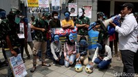 Tampak sejumlah demonstran mengenakan topeng berwarna biru dengan gambar sebuah tangan yang memiliki warna seperti bendera China.