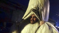 Penari bertopeng melihat melalui rambut topengnya saat ia mengambil bagian dalam ritual kuno mengusir roh-roh jahat di jalan-jalan Batanovci, Bulgaria.