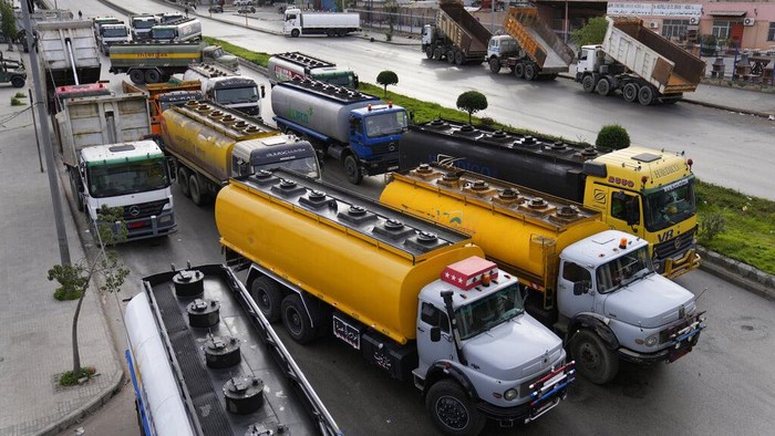 Tanker trucks block a main highway during a general strike by public transport and labor unions to protest the country's deteriorating economic and financial conditions in Beirut, Lebanon, Thursday, Jan. 13, 2022. Protesters closed the country's major highways as well as roads inside cities and towns starting 5 a.m. making it difficult for people to move around. (AP Photo/Hussein Malla)