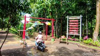 Sesampainya di taman ini, pengunjung akan disambut gapura bambu yang menjadi gerbang utama Taman Tresno Jasa Marga. Gapura berwarna merah itu dihiasi payung warna warni yang ditempel di sepanjang jalan setapak menuju area inti taman. Adapun jarak dari pintu masuk sampai ke dalam taman berkisar 50 meter. Foto: Jalu Rahman Dewantara/detikcom