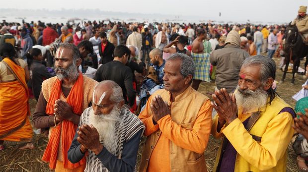 Hindu devotees crowd the Sangam, the confluence of three rivers — the Ganges, the Yamuna and the mythical Saraswati, to take a ritualistic bath during Makar Sankranti festival that falls during the annual traditional fair of Magh Mela festival, one of the most sacred pilgrimages in Hinduism, in Prayagraj, India. Friday, Jan. 14, 2022. Tens of thousands of devout Hindus, led by heads of monasteries and ash-smeared ascetics, took a holy dip into the frigid waters on Friday despite rising COVID-19 infections in the country. (AP Photo/Rajesh Kumar Singh)