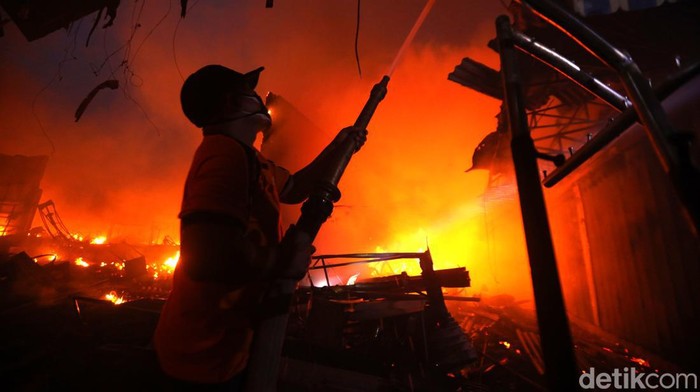 Petugas pemadam kebakaran berusaha memadamkan api yang melalap pasar Bajul Mati di Wongsorejo, Banyuwangi, Jawa Timur, Sabtu (15/1/2022). Kebakaran yang terjadi sekitar pukul 02.00 wib itu menghanguskan sebagian besar los pasar yang rata-rata lapak penjual pakaian. ANTARA FOTO/Budi Candra Setya/nym.