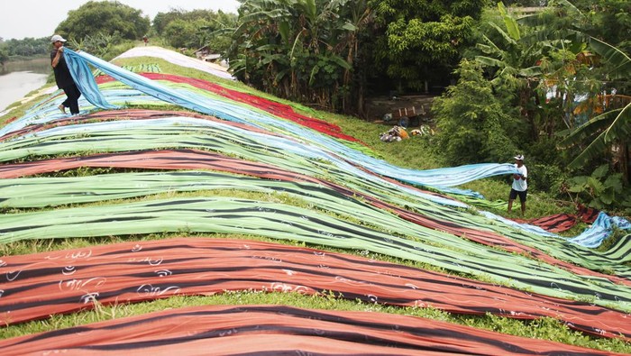 KERAJINAN KAIN PANTAI Pekerja menjemur kain pantai usai proses pewarnaan di sentra kerajinan kain Desa Krajan, Mojolaban, Sukoharjo, Jawa Tengah, Sabtu (15/1/2022). Kain pantai yang telah kering dan dipotong akan dijadikan bahan baku pembuatan pakaian untuk dipasarkan ke berbagai kawasan wisata di Indonesia seperti Yogyakarta, Solo, Jakarta dan Bali. ANTARAFOTO/Maulana Surya/nym.