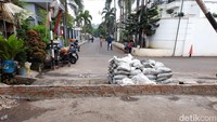 Tanggul ini bukan berada di bantaran kali, melainkan melintang di tengah jalan perumahan. Tanggul ini mengganggu lalu lintas warga.