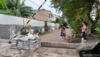 Tanggul ini dibangun salah satu warga yang terganggu oleh banjir. Dengan adanya tanggul, dia berharap rumahnya tak lagi kebanjiran. Namun, masalah lain muncul. Akes jalan warga terganggu.