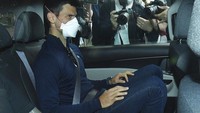 Petenis Serbia Novak Djokovic meninggalkan fasilitas penahanan pemerintah untuk menghadiri sidang pengadilan di kantor pengacaranya di Melbourne, Australia, Minggu (16/1/2021). AP Photo/James Ross.