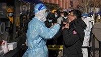 Pada hari Minggu (16/1) terjadi antrian berjam-jam untuk tes Covid-19 di luar Rumah Sakit Beijing. Mereka mengantre dengan kondisi suhu dingin. Menurut data Komisi Kesehatan Nasional (NHC) China daratan melaporkan 119 kasus COVID-19 baru pada Sabtu (15/1), termasuk transmisi lokal. Jumlah ini turun dari hari sebelumnya dengan total 165 kasus. Adapun tidak ada kasus kematian baru yang dilaporkan. Dengan begitu, jumlah kasus kematian COVID-19 di China berjumlah 4.636. AP Photo/Andy Wong.