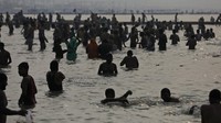 Meski di India kasus virus corona tengah meningkat, puluhan ribu warganya yang taat tetap melaksanakan ritual mandi suci di sungai. (AP/Rajesh Kumar Singh)