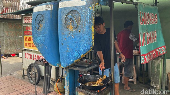 Pedagang kaki lima memanfaatkan bekas fasilitas telpon umum yang telah usang menjadi tempat masak, di kawasan Bendungan Hilir, Jakarta pusat, Senin (17/01/2022).