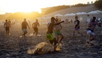Para pria bermain sepak bola di pantai di tengah gelombang panas musim panas di Carilo, provinsi Buenos Aires, Argentina. (AP/Rodrigo Abd)