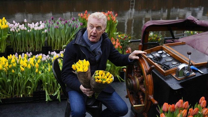 Berbagi Bunga Tulip Gratis Usai Lockdown di Belanda On the day stores in Amsterdam and across the Netherlands cautiously re-opened after weeks of coronavirus lockdown, the Dutch capital's mood was further lightened by dashes of color in the form of thousands of free bunches of tulips handed out by growers from a boat in the canals of Amsterdam, Netherlands, Saturday, Jan. 15, 2022. (AP Photo/Peter Dejong)