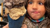 Kepingan es krim di hadapannya memecah fokus bocah yang satu ini. Kedua matanya fokus ke tengah dan lidahnya dijulurkan ke samping, membuatnya terlihat gemas! Foto: Instagram/foodbabyny