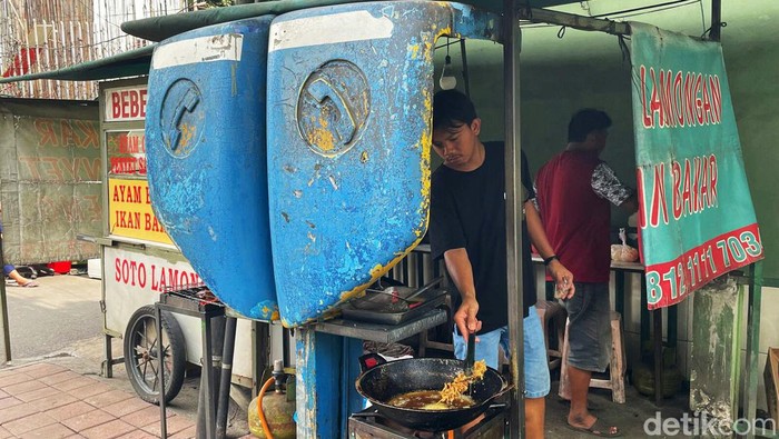 Pedagang kaki lima berjualan memanfaatkan fasilitas telpon umum yang telah usang, di kawasan Bendungan Hilir (Benhil), Jakarta pusat, Senin (17/1/2022).