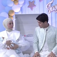 Sementara sang suami, Rizky Billar, tampak memakai kemeja kerah tinggi dan celana putih yang dipadu outer berpotongan tailoring aksen emboss. Foto: Instagram/@askar_photography, YouTube Indosiar