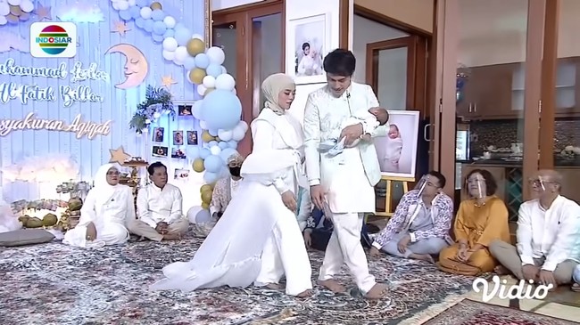 Kesan mewah tampak dari outer berdetail pita dengan ekor panjang menyapu lantai. Foto: Instagram/@askar_photography, YouTube Indosiar