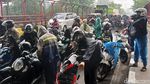 Hujan, Pengendara Motor Berteduh di Bawah Tol MBZ