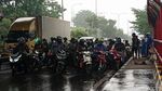 Hujan, Pengendara Motor Berteduh di Bawah Tol MBZ