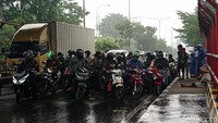 Ruas jalan pun mengalami penyempitan karena banyaknya pengendara sepeda motor yang berteduh.
