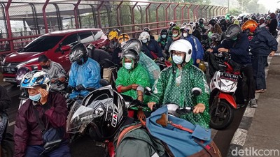 Hujan, Pengendara Motor Berteduh di Bawah Tol MBZ