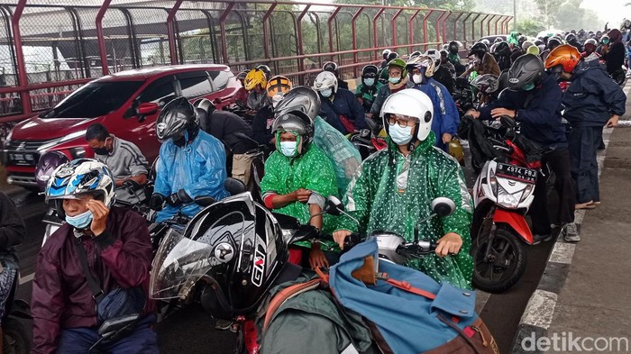 Ratusan pengemudi sepeda motor berteduh saat hujan di bawah Tol Layang MBZ, Jalan Cut Mutia, Kota Bekasi, Jawa Barat, Senin (17/1/2021). Hal ini mengganggu kalancaran lalu lintas.
