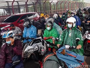 Hujan, Pengendara Motor Berteduh di Bawah Tol MBZ