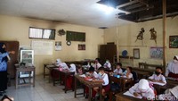 Sebagian plafon di kelas tersebut ambrol, menyisakan lubang menganga tepat di atas para siswa. 