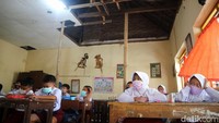 Para siswa belajar di ruang kelas dengan plafon yang nyaris ambrol.