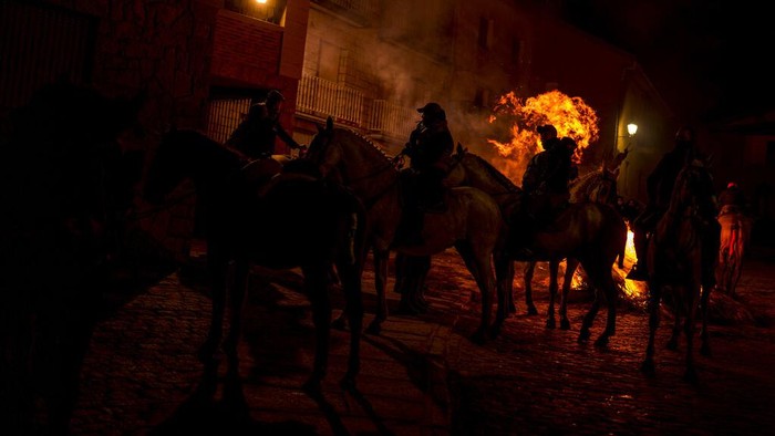 Tradisi Menembus Kobaran Api Untuk Menyucikan Kuda A man rides a horse through a bonfire as part of a ritual in honor of Saint Anthony the Abbot, the patron saint of domestic animals, in San Bartolome de Pinares, Spain, Sunday, Jan. 16, 2022. On the eve of Saint Anthony's Day, dozens ride their horses through the narrow cobblestone streets of the small village of San Bartolome during the