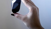 Pegawai rumah lelang Sothebys menunjukan berlian hitam The Enigma di Dubai, UEA, (17/1/2022). Berlian dengan sebutan The Enigma ini diperkirakan akan dijual setidaknya dengan harga 5 juta pound Inggris atau setara dengan Rp 97,5 miliar.