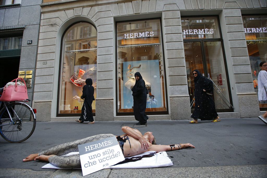 An activist of People for the Ethical Treatment of Animals, PETA stages a protest against Hermes at Milan's fashion shopping district, in Milan, Italy, Thursday, July 30 , 2015. British singer Jane Birkin has asked Hermes to take her name off the crocodile-skin versions of the iconic Birkin handbag, after being contacted by animal rights group PETA over 