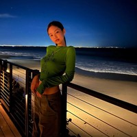 Salah satu fotonya berlatar pemandangan pantai di malam hari. Terlihat kasual, Jennie memadukan atasan crop berwarna hijau dengan baggy pants berwarna coklat. Foto: dok Instagram jennierubyjane.
