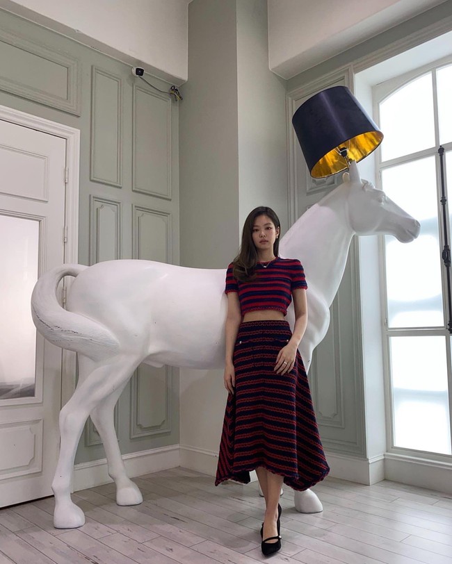 Terlihat semi formal, Jennie memakai atasan crop dan rok asimetris berbahan rajut. Set garis-garis bernuansa merah dan biru itu dipadukan dengan flat shoes hitam. Foto: dok Instagram jennierubyjane.