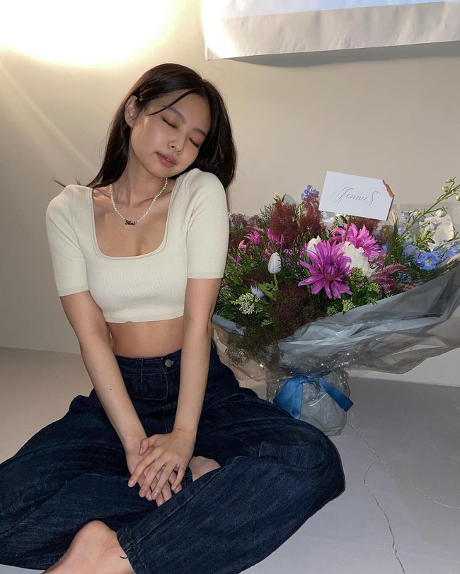 Jennie pun membagikan fotonya memakai atasan crop berwarna krem. Penampilannya semakin manis dengan kalung mutiara yang bertuliskan nama panggilannya ‘Nini’. Foto: dok Instagram jennierubyjane.