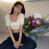 Jennie pun membagikan fotonya memakai atasan crop berwarna krem. Penampilannya semakin manis dengan kalung mutiara yang bertuliskan nama panggilannya ‘Nini’. Foto: dok Instagram jennierubyjane.