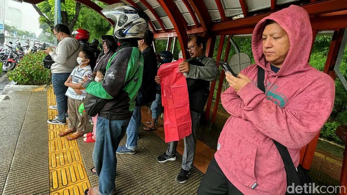 Hujan deras yang mengguyur wilayah Jakarta membuat sejumlah pemotor berhenti sejenak. Halte bus pun jadi pilihan para pemotor untuk berteduh.