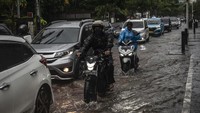 Kendaran melintasi genangan banjir di Jalan Cikini Raya, Jakarta.