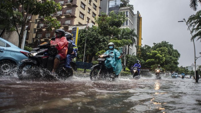 Jalan Cikini Raya Direndam Banjir Sepeda motor melintas di trotoar untuk menghindari genangan banjir di Jalan Cikini Raya, Jakarta, Selasa (18/1/2022). Banjir tersebut terjadi karena buruknya drainase di kawasan itu serta tingginya instensitas hujan pada Selasa (18/1) siang. ANTARA FOTO/Aprillio Akbar/foc.