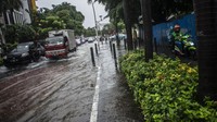 Sepeda motor melintas di trotoar untuk menghindari genangan banjir di Jalan Cikini Raya, Jakarta, Selasa (18/1/2022). Banjir terpantau sekitar pukul 12.00 WIB.