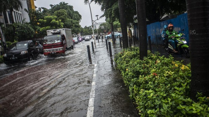 Jalan Cikini Raya Direndam Banjir Sepeda motor melintas di trotoar untuk menghindari genangan banjir di Jalan Cikini Raya, Jakarta, Selasa (18/1/2022). Banjir tersebut terjadi karena buruknya drainase di kawasan itu serta tingginya instensitas hujan pada Selasa (18/1) siang. ANTARA FOTO/Aprillio Akbar/foc.