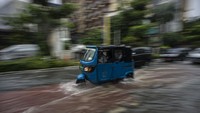 Bajaj melintasi genangan banjir di Jalan Cikini Raya, Jakarta.
