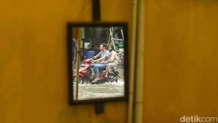 Hujan deras yang mengguyur Bekasi membuat sebagian wilayah terendam banjir. Salah satunya di Jalan Raya Pondok Ungu Permai, Babelan, Selasa (18/1/2022).